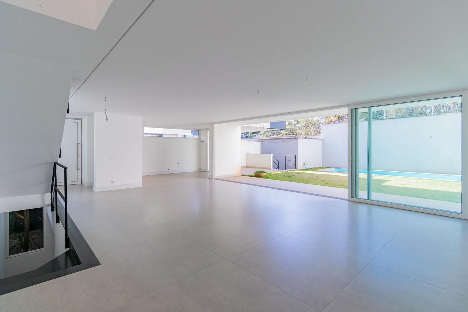 Living com pé direito alto e vista para o jardim