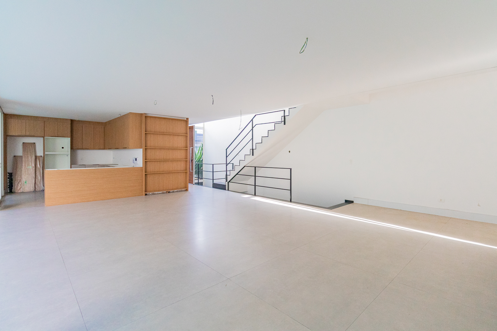 Sala de estar ampla com escada e pé-direito duplo