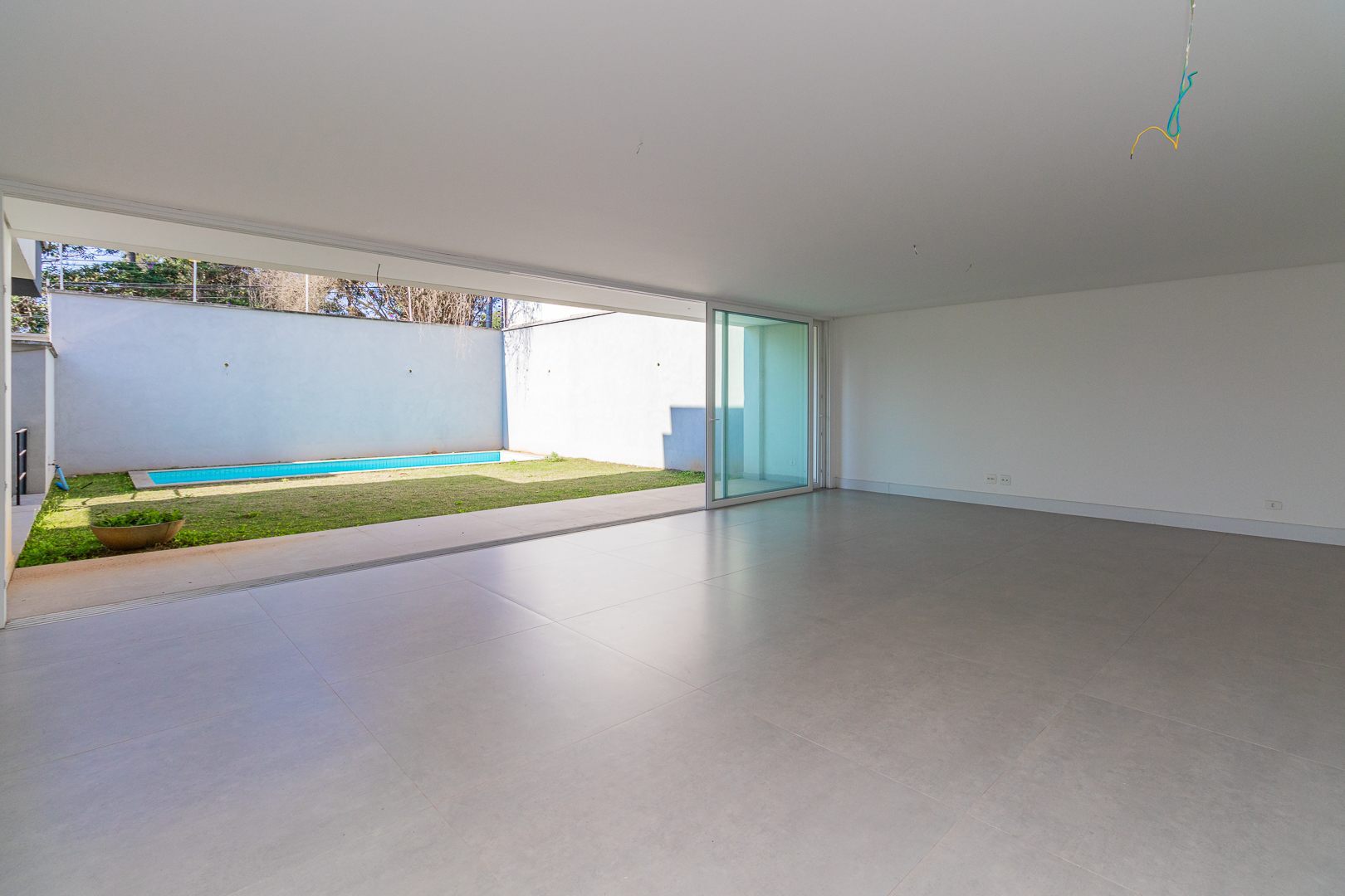 Living amplo com vista para piscina e jardim