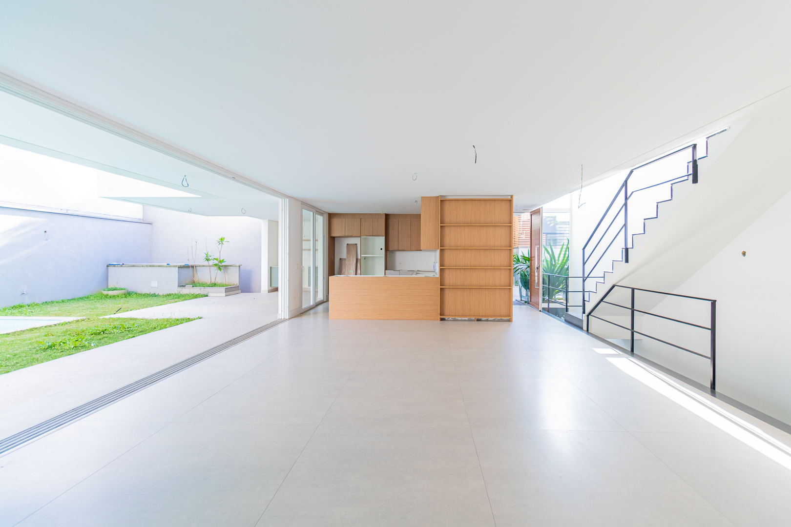 Living integrado à cozinha e ao jardim com piscina